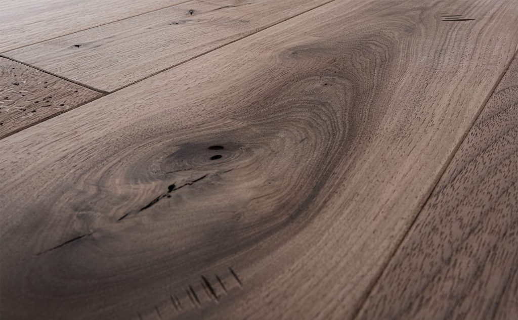 Walnut hardwood flooring with distressed texture close up.