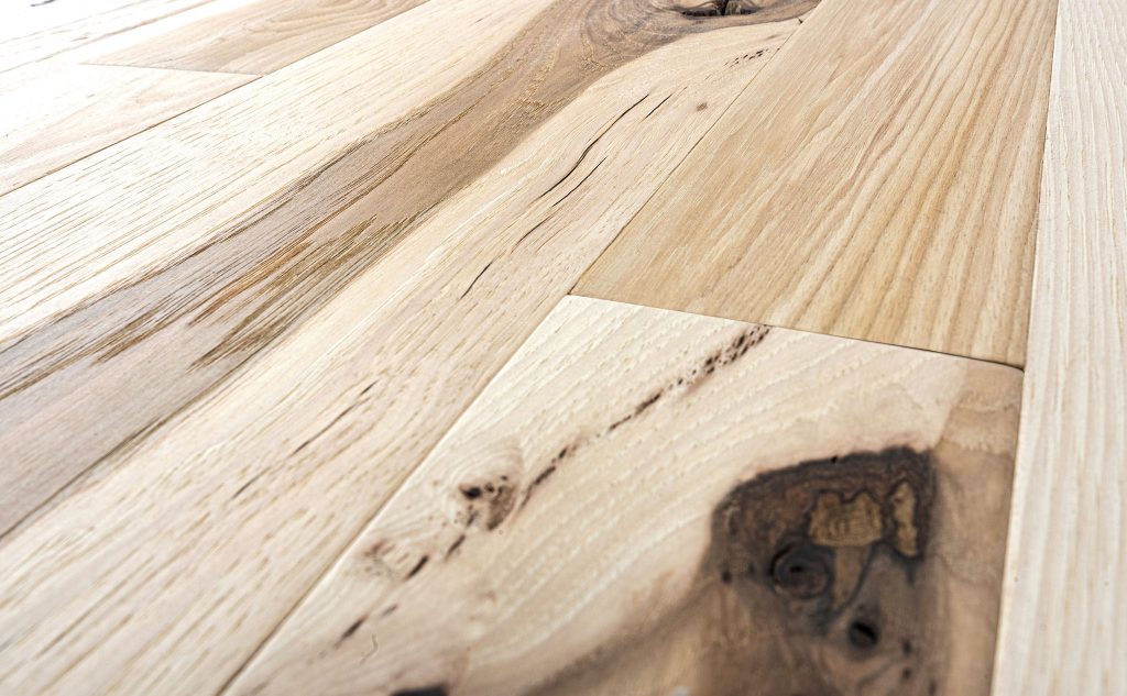 Hickory hardwood flooring with foot worn texture close up.