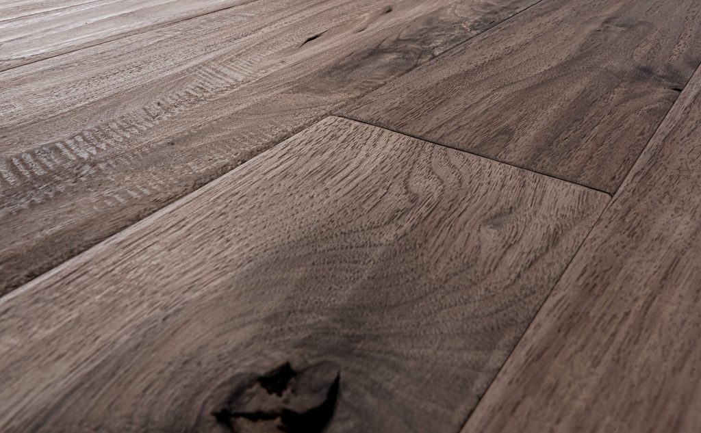 Walnut hardwood flooring with hand scraped and wire brushed texture close up.