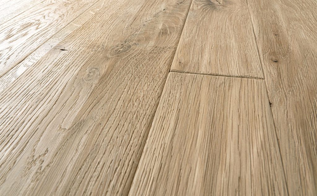 White oak hardwood flooring with hand scraped wire brushed texture close up.