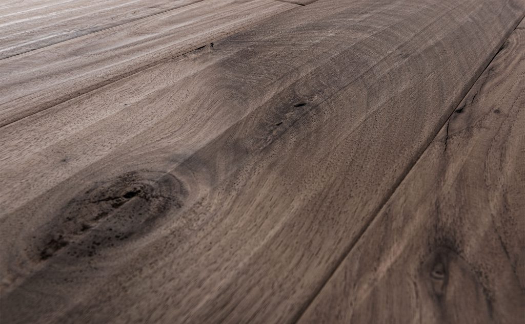 Walnut hardwood flooring with hand scraped texture close up.