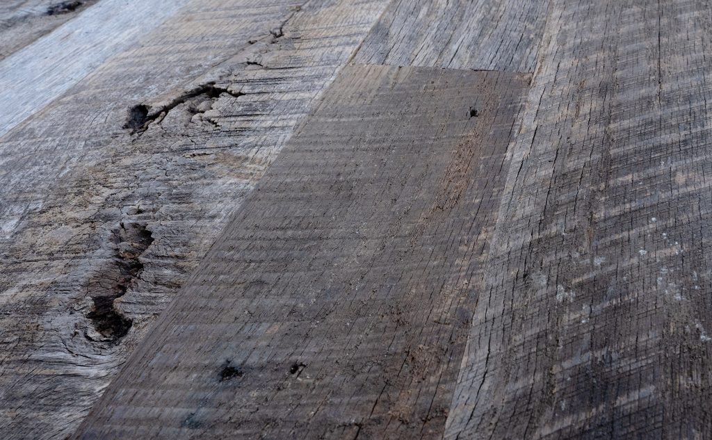 Antique oak hardwood flooring with original texture close up.