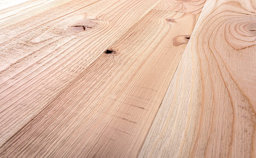 Douglas fir hardwood flooring with skip band wire brushed texture close up.