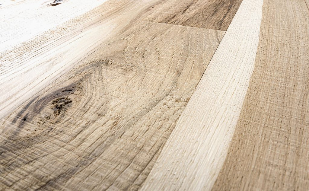 Hickory hardwood flooring with skip band and wire brushed texture close up.