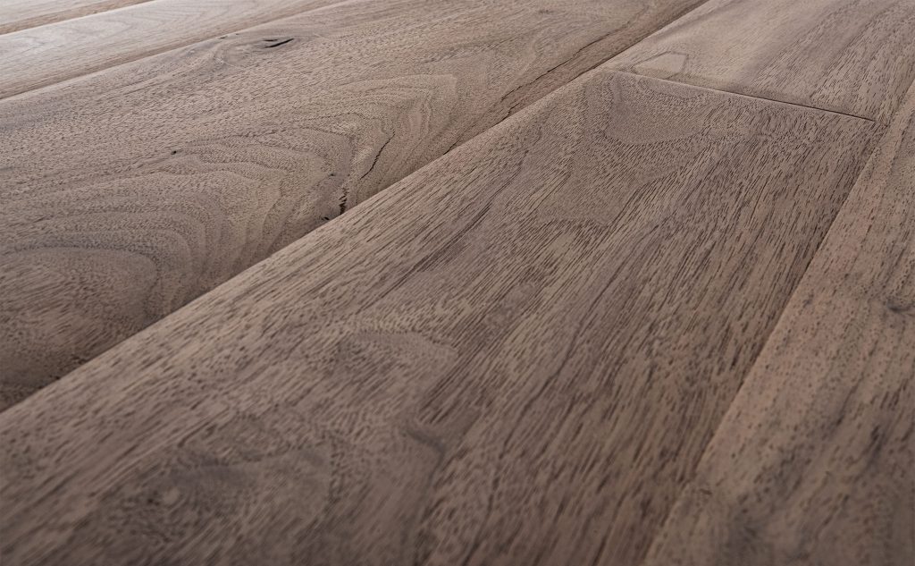 Smooth walnut hardwood flooring with chalet texture close up.