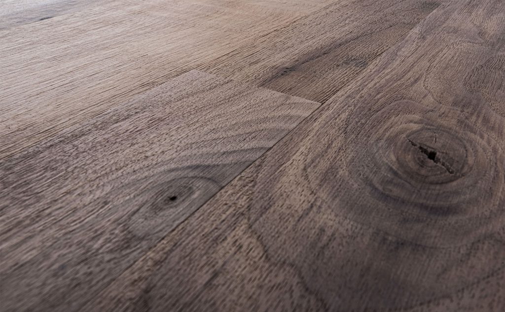 Walnut hardwood flooring with wire brush texture close up.